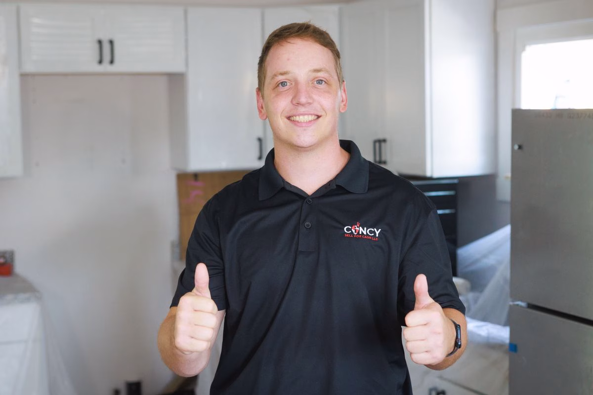 Patrick Fitzgerald in a Cincy Sell for Cash shirt giving two thumbs up in a Cincinnati kitchen under renovation